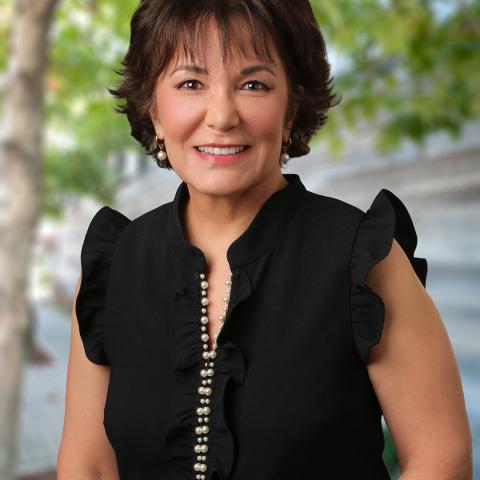 Photo of Beth Rustigian Broussalian with trees in background.
