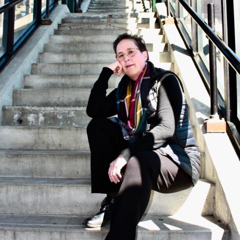 Patricia Bouteneff sits on a set of stairs and looks at the reader.