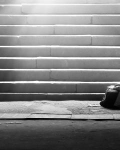 Homeless woman reading the book in subway under the sunlight 