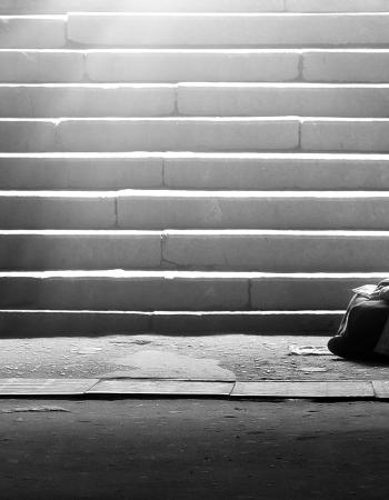 Homeless woman reading the book in subway under the sunlight 