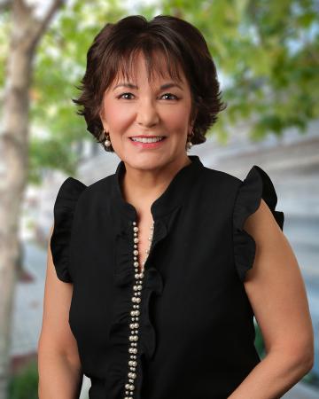 Photo of Beth Rustigian Broussalian with trees in background.