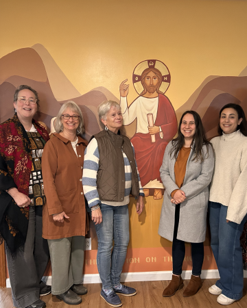 Patricia Bouteneff and others stand with an icon of Jesus
